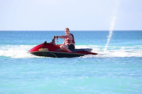 Giovane ragazzo crociera su un jet ski sul mare caraibico — Foto Stock