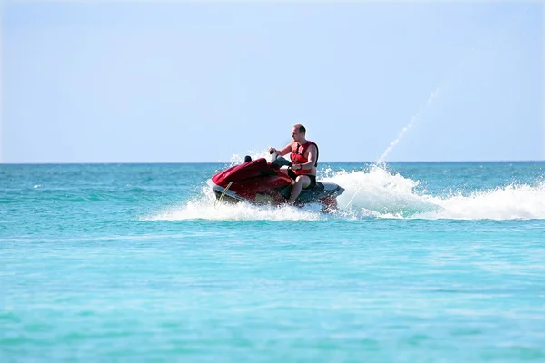 Jovem viajando em um jet ski no mar do Caribe — Fotografia de Stock