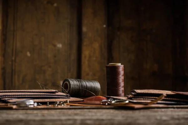 Шкіряні інструменти для ремесел на старому дерев'яному столі. Шкіряна майстерня ремесел . — стокове фото