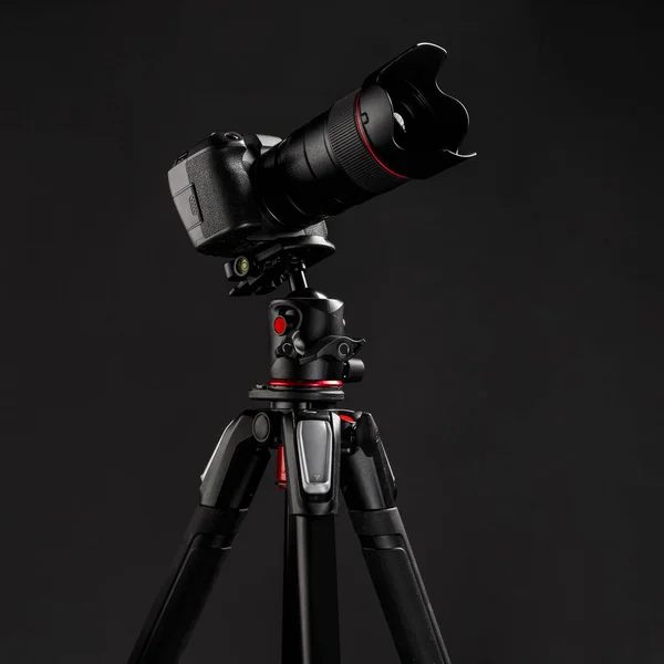 Professional photography equipment, digital mirrorless camera on tripod with dark gray background