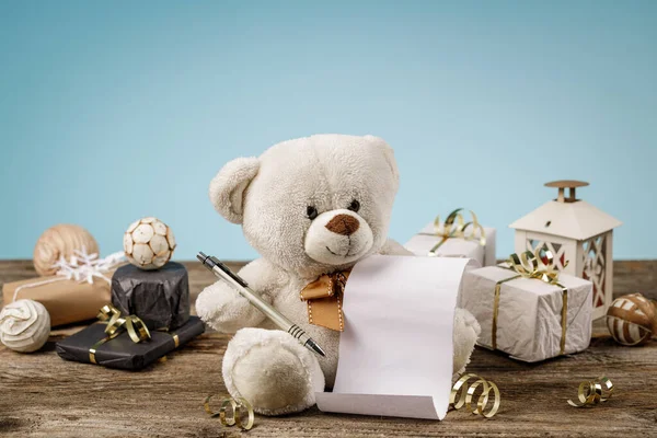 Ours en peluche adorable blanc ou brun clair avec des achats vides ou une liste de souhaits et des décorations et cadeaux de Noël brillants et scintillants. Concept de vacances avec peluche jouet ours et cadeaux de Noël sur le bois — Photo