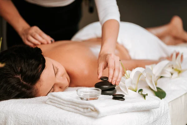 Mulher bonita no salão de massagem com cabelo encaracolado marrom e pele saudável. Conceito de massagista e paciente. — Fotografia de Stock