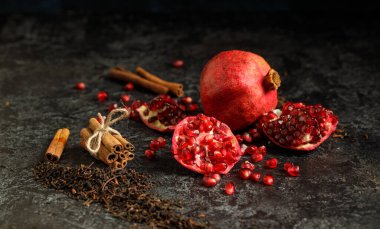 Koyu renkte kurumuş çay yaprağı, nar ve sinamonlu grunge arka plan. Metin için boş alan. Lezzetli sağlıklı meyve. 