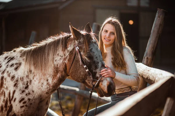 Beautiful young girl posing with her horse in the nature. Sunny autumn day. — Stock Photo, Image