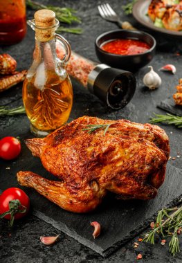 Ev yapımı ızgara kızarmış tavuk, Holden kahverengi kabuklu, siyah taş tabakta domates, biberiye ve sos.