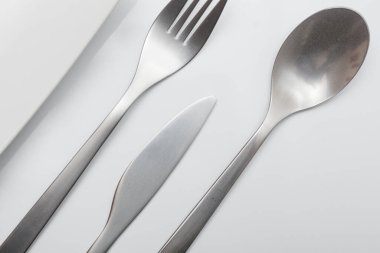 Beyaz arkaplanda en az tasarlanmış inoks çatal bıçak takımı