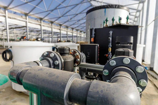 Large industrial water treatment and boiler system in a greenhouse with many pipes and valves