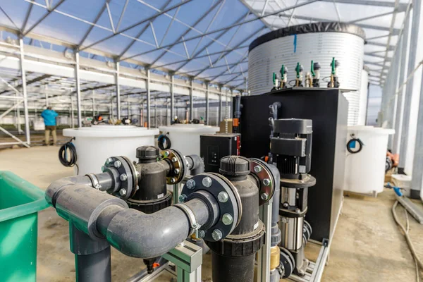 Large industrial water treatment and boiler system in a greenhouse with many pipes and valves