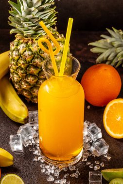 Lezzetli soğuk portakal suyu kokteyl bardağında ananas, kivi ve muzlu içecek.