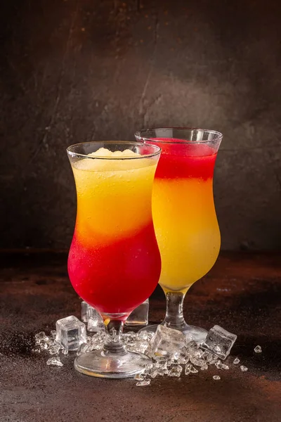 Deliciosas bebidas refrescantes de licuados coloridos fríos en vasos de cóctel con frutas — Foto de Stock