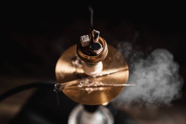 Sakallı adama karşı nargileyi kapat. Karanlık bir odada tüten Shisha, beyaz duman bulutu