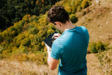 Doğada çalışan tabletli bir orman yürüyüşçüsü.
