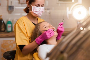 Güzel sarışın kadınların dişleri diş hekimliğinde kontrol ediliyor.