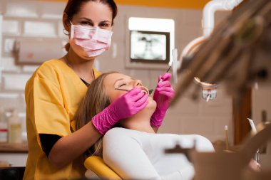 Güzel sarışın kadınların dişleri dişçi tarafından kontrol ediliyor.