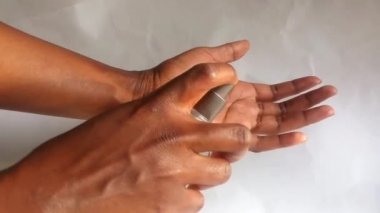 El dezenfektanı kullanan kahverengi eller. Kadın eli işte. Eline sprey sıkmış ve ellerini birbirine sürtmüş. Temizlik, hijyen. Covid-19, 2019-ncov, koronavirüs. Kopyalama. Beyaz arkaplan.