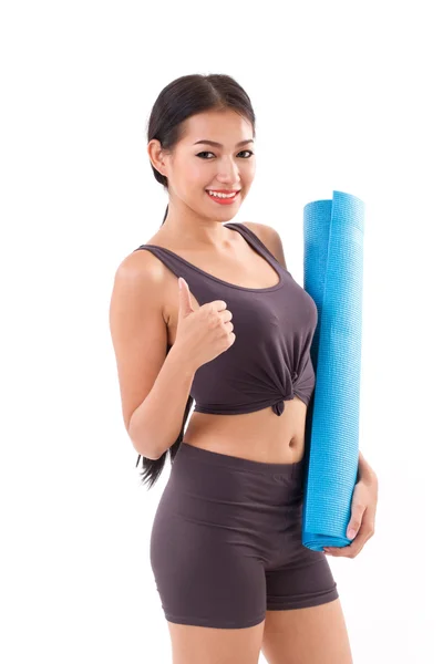 Fitness mujer con mano sosteniendo yoga mat, dando pulgar hacia arriba — Foto de Stock