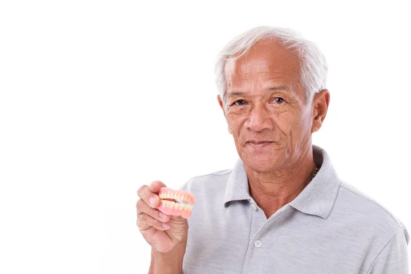 Anciano con prótesis dentales en la mano — Foto de Stock