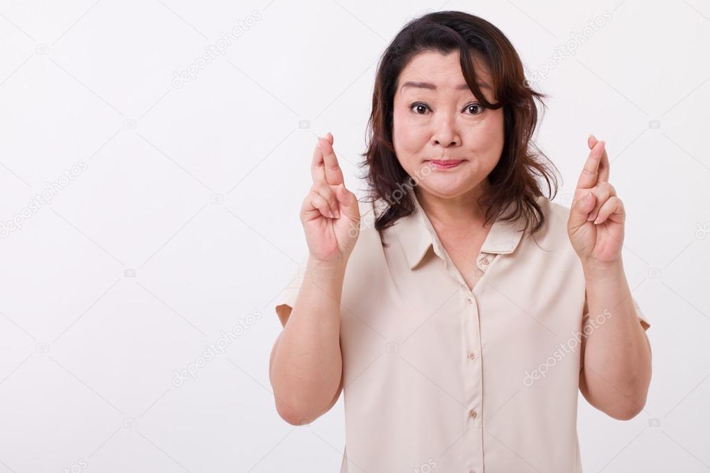 middle aged woman with finger crossed
