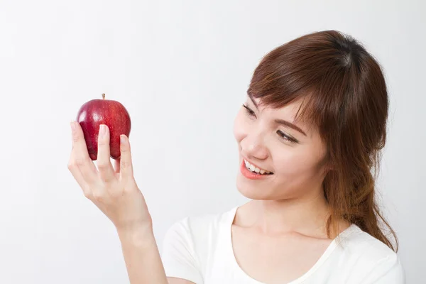 Здорова азіатська жінка дивиться, рука тримає червоне яблуко — стокове фото
