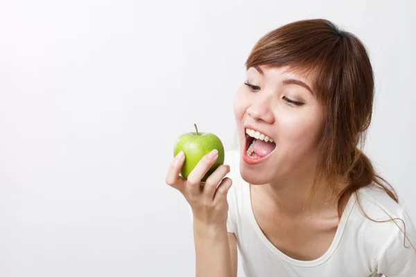 Sana mujer asiática mirando hacia arriba mientras mordiendo, comiendo manzana verde —  Fotos de Stock