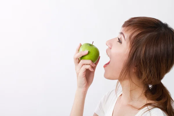 Gezonde Aziatische vrouw opzoeken terwijl bijten, groene appel eten — Stockfoto