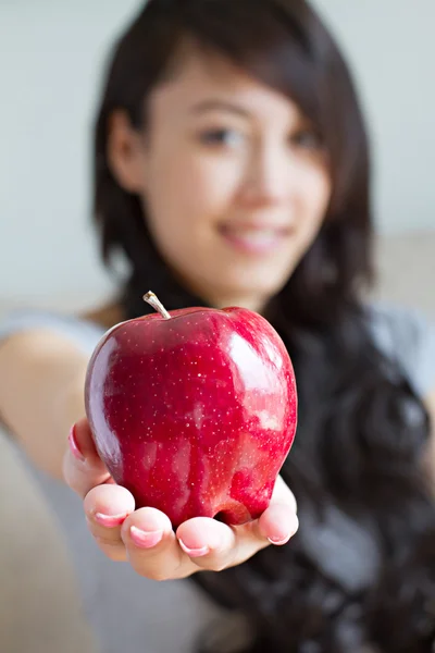 Saludable mujer con rojo manzana, mixta raza asiático caucásico interior —  Fotos de Stock