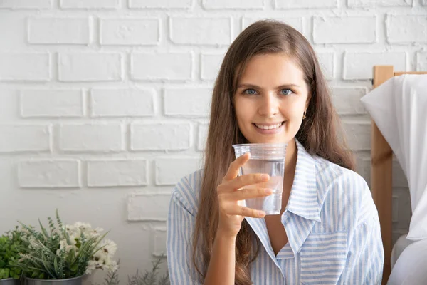 woman drinking fresh water; portrait of asian woman drinking fresh, clean water, concept of health care, sufficient hydration, good diet; caucasian woman model