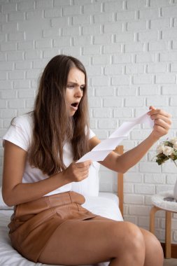 frustrated, shocked, stressed women with expensive bill, debt invoice, eviction notice; concept of high cost of living, expensive bill, getting busted, economic recession, no job no money clipart