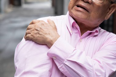 Asyalı yaşlı bir adam omuz eklem ağrısı, osteoporoz, kemik kütlesi kaybı yaşıyor.