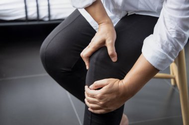 Diz ağrısı, diz eklem yaralanması, gut, romatoid, osteoporoz geçiren orta yaşlı hasta kadın.