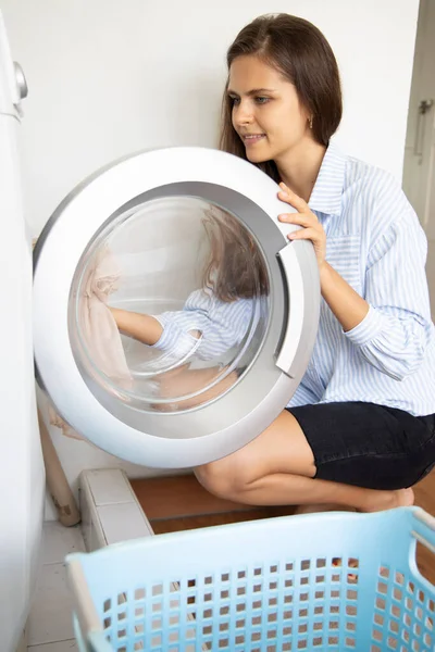 happy woman doing laundry howsework, washing cloth with laundry machine
