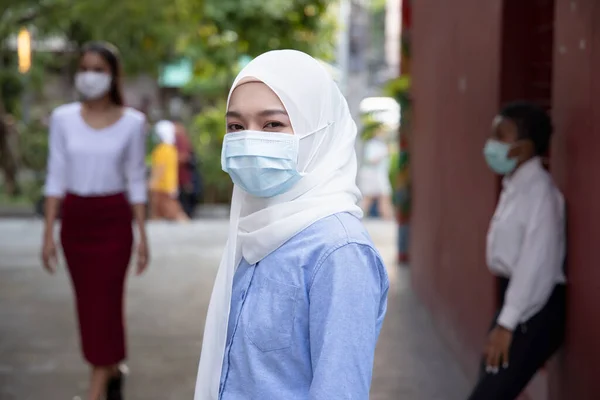 イスラム教徒のイスラム教徒の女性やイスラム教徒のヒジャーブとフェイスマスクを着用し 社会的距離の新しい通常の生活様式を観察し 公共の場で他の人との距離を保つ — ストック写真