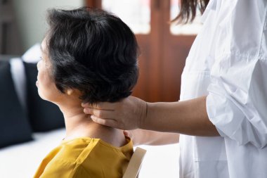 Asyalı bakıcı emekli yaşlı kadına masaj yapıyor, emeklilik konsepti, huzurevi, huzurevi, emeklilik hizmeti, bakıcılık işi.