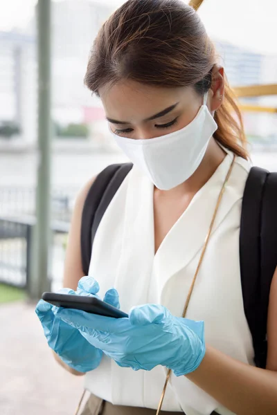 woman with blue rubber glove using smartphone, concept of telemedicine, online shopping, online food or grocery delivery order, new norm, new normal social distancing, personal distancing technology
