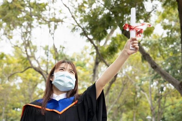 Χαρούμενος Χαμογελαστός Ασιάτης Φοιτητής Που Κατέχει Πτυχίο Πανεπιστημίου Φορώντας Μάσκα — Φωτογραφία Αρχείου