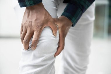 Diz eklem ağrısı ve kemik iltihabı olan Afrikalı yaralı bir adam var.