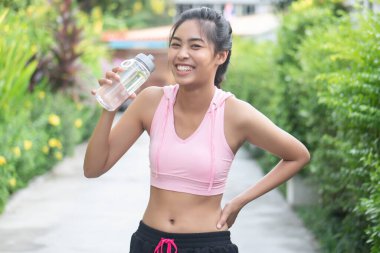 Kadın koşucu içme suyu, koştuktan, koştuktan, spor yaptıktan, egzersiz yaptıktan, izokinetik egzersiz, sağlık konsepti, vücut bakımı, fitness hidrasyonu veya rehidrasyon