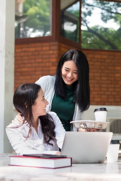 Happy asian woman college student studying and drinking coffee in university campus, concept of back to school, video call online learning class, online education lifestyle, sharing concept