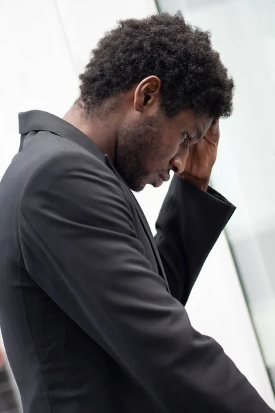 Upset stressed African black businessman having headache, portrait of failed unhappy black business man, concept of work problem, office stress syndrome, economic recession, layoff, unemployment