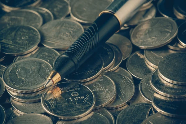 Деньги концепция монет и ручка с эффектом фильтра ретро винтажный хлев — стоковое фото