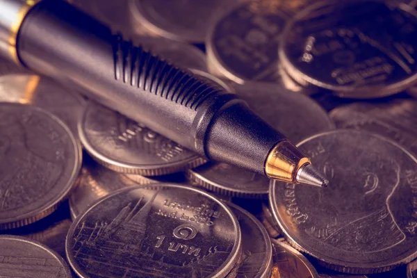 Pengar konceptet mynt och penna med filter effekt retro vintage stil — Stockfoto