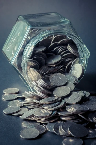 Monedas derramadas de una botella de vidrio con efecto filtro retro vi — Foto de Stock