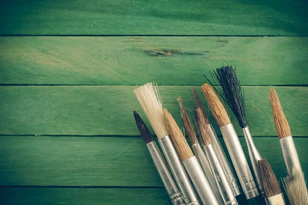 Pennello su legno verde con mano effetto filtro retrò stile vintage — Foto Stock