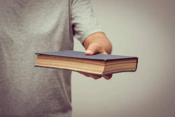 Hands holding old book with filter effect retro vintage style — Stock Photo, Image