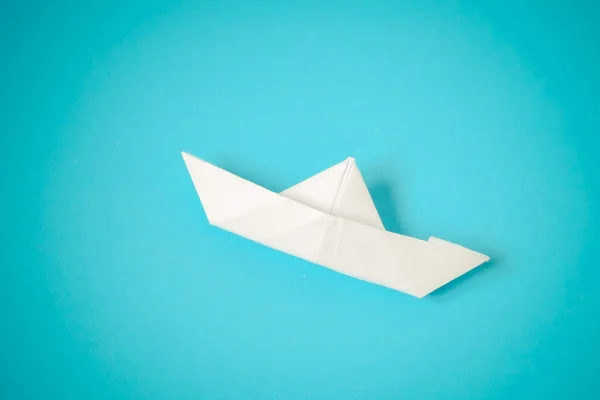 Paper boat on blue background — Stock Photo, Image