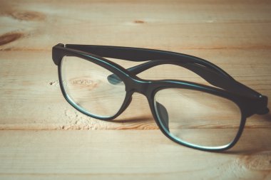 Eski kitaplar ve gözlük retro filtre efekti ile ahşap bir masa üzerinde