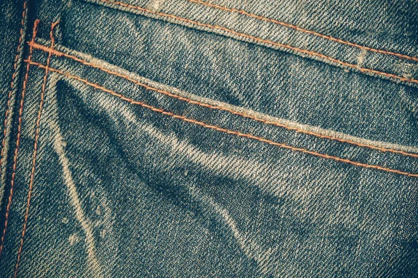 Tekstura tło niebieskie jeansy z filtr efektu retro ubierania — Zdjęcie stockowe