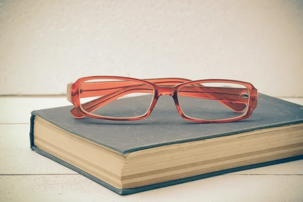 stock image Old books and glasses on a wooden table with filter effect retro