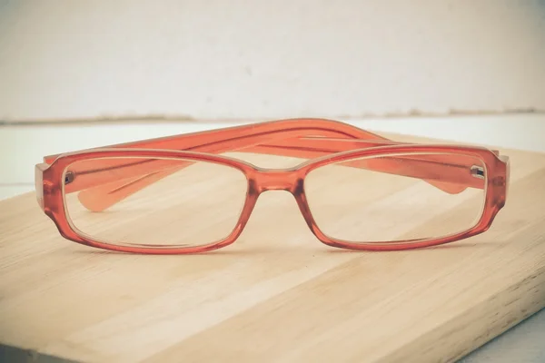 Bril op een houten tafel met filtereffect retro — Stockfoto