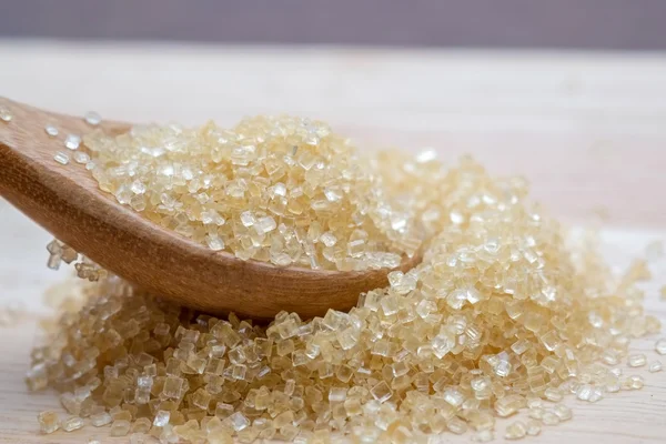 Brown sugar heap on wooden table — Stock Photo, Image